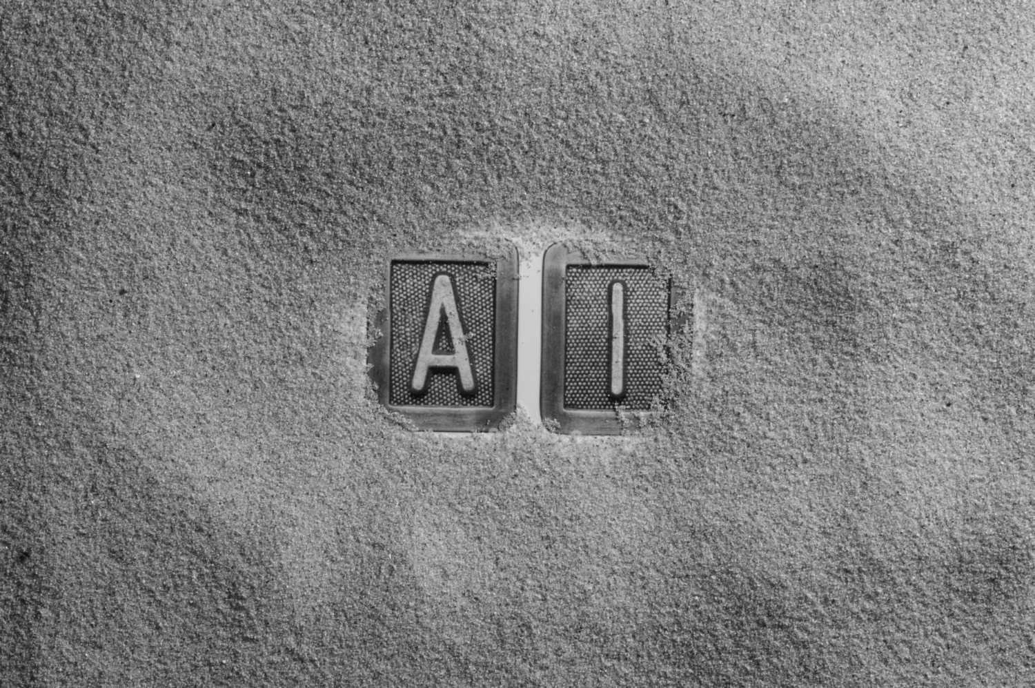 Letras AI dibujadas sobre la arena